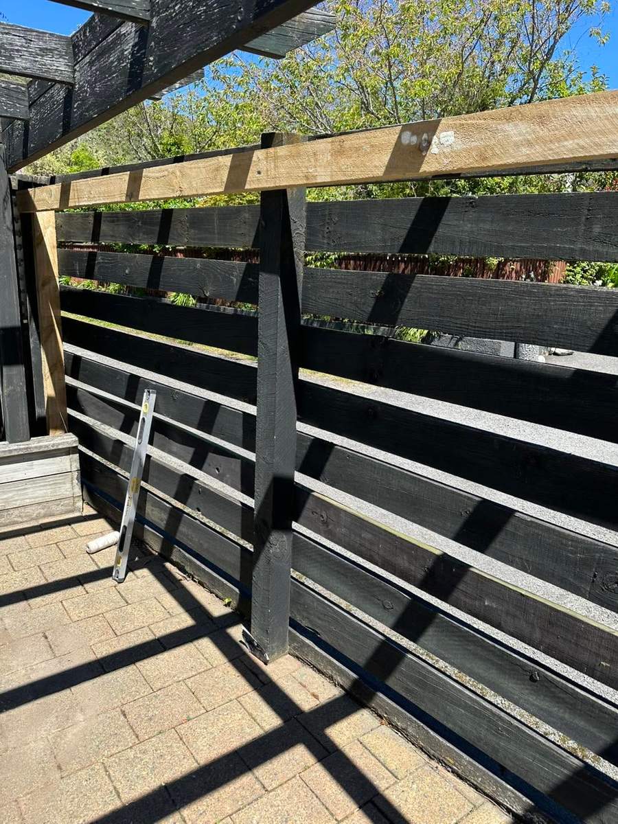 New composite fence panel beside an old paling fence