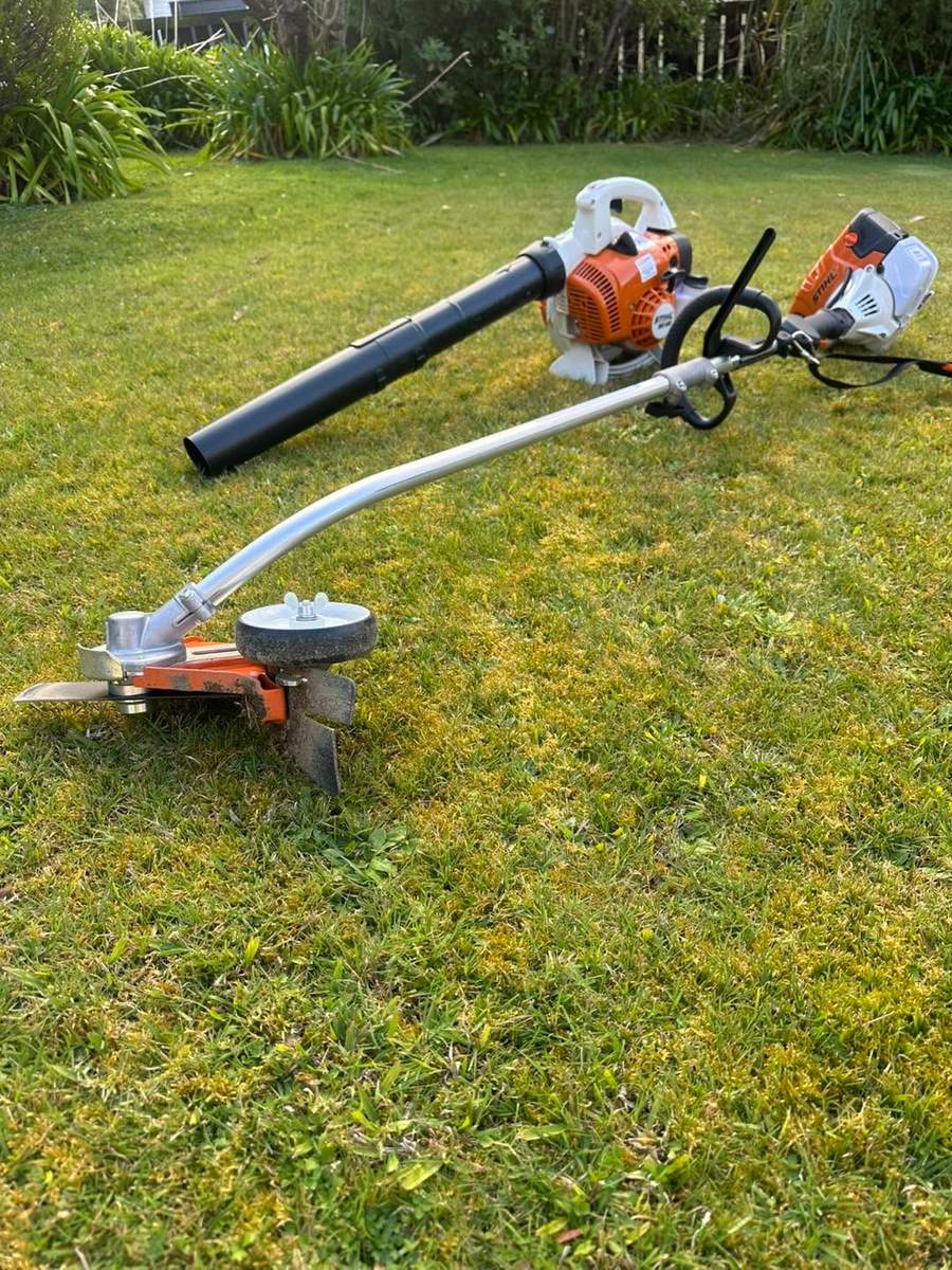 Mowing and trimming equipment laid out on a lawn